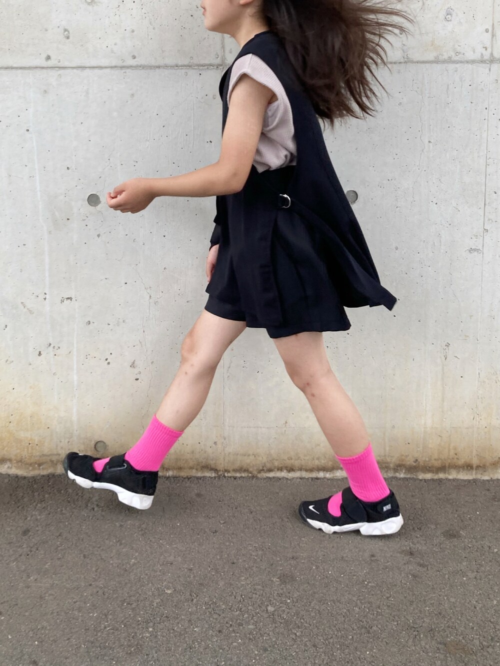 グレー系のタンクトップ、グレー系のベスト、ブラック系のスニーカーを着用したキッズの秋コーディネートの5枚目の写真