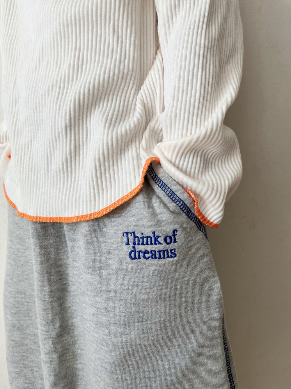 グレー系のTシャツ/カットソー、グレー系のスカート、ブラック系のMA-1を着用したキッズの冬コーディネートの4枚目の写真