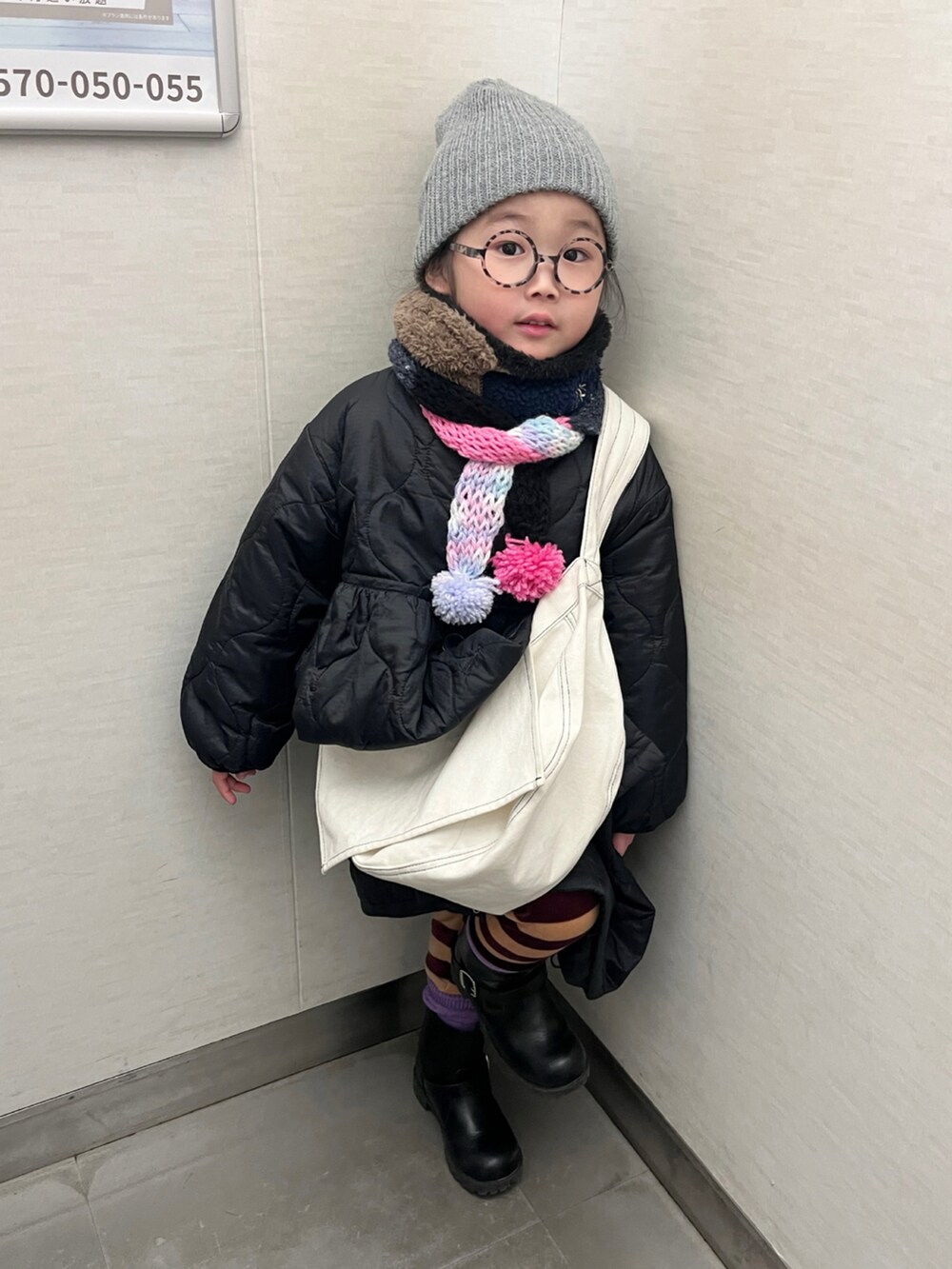 ブラック系のミリタリージャケット、グレー系のTシャツ/カットソー、ベージュ系のその他パンツを着用したキッズの冬コーディネートの5枚目の写真