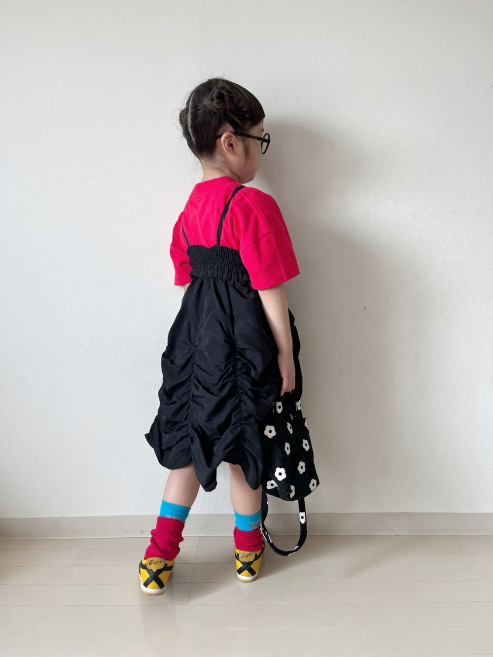 レッド系のTシャツ/カットソー、ブラック系のスカート、ブラック系のショルダーバッグを着用したキッズの春コーディネートの3枚目の写真