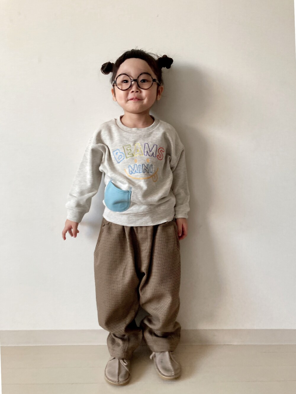 ホワイト系のスウェット、ブラウン系のその他パンツ、ブラウン系のブーツを着用したキッズの秋コーディネートの3枚目の写真