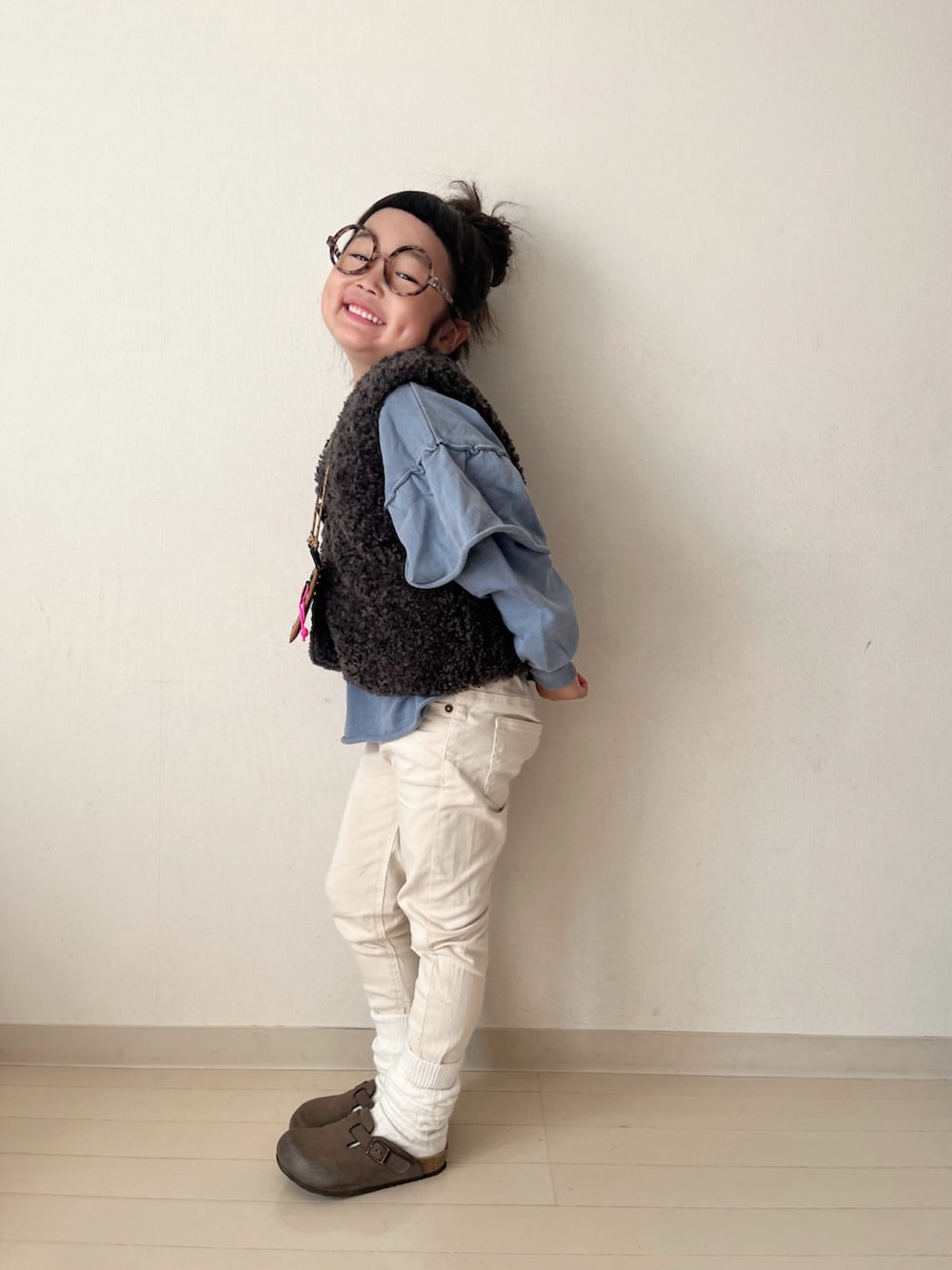 ブルー系のスウェット、グレー系のベスト、ホワイト系のその他パンツを着用したキッズの秋コーディネートの3枚目の写真