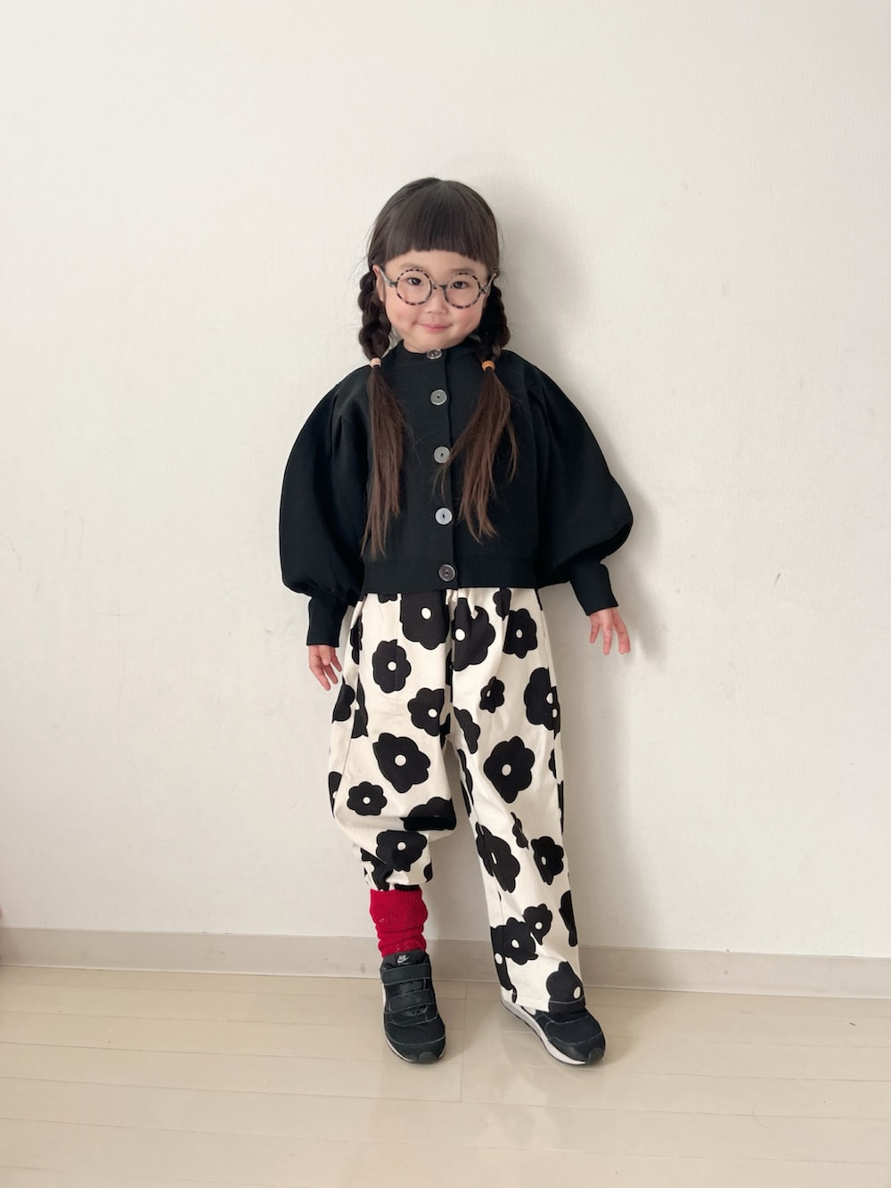 ホワイト系のその他パンツ、ブラック系のカーディガン/ボレロ、ブラック系のスニーカーを着用したキッズの冬コーディネートの3枚目の写真