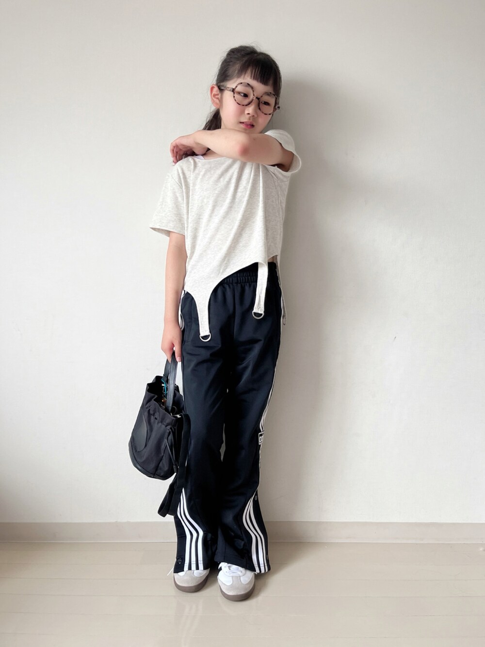 ベージュ系のTシャツ/カットソー、ブラック系のその他パンツ、ホワイト系のスニーカーを着用したキッズの夏コーディネートの2枚目の写真