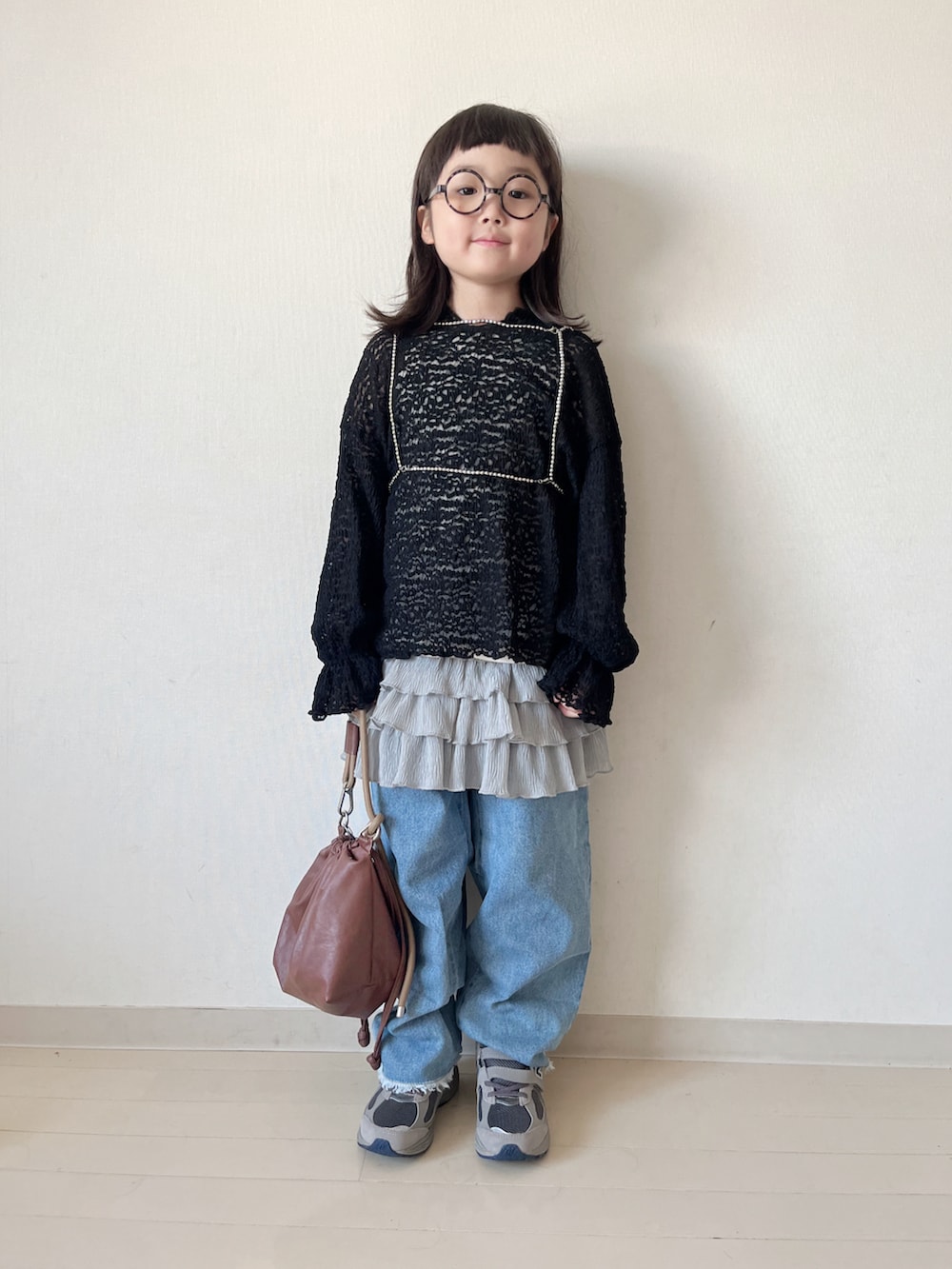 ブラック系のTシャツ/カットソー、ブラウン系のショルダーバッグ、グレー系のスカートを着用したキッズの秋コーディネートの2枚目の写真