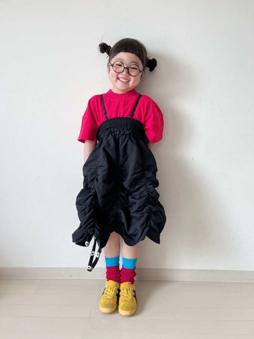 レッド系のTシャツ/カットソー、ブラック系のスカート、ブラック系のショルダーバッグを着用したキッズの春コーディネートの2枚目の写真