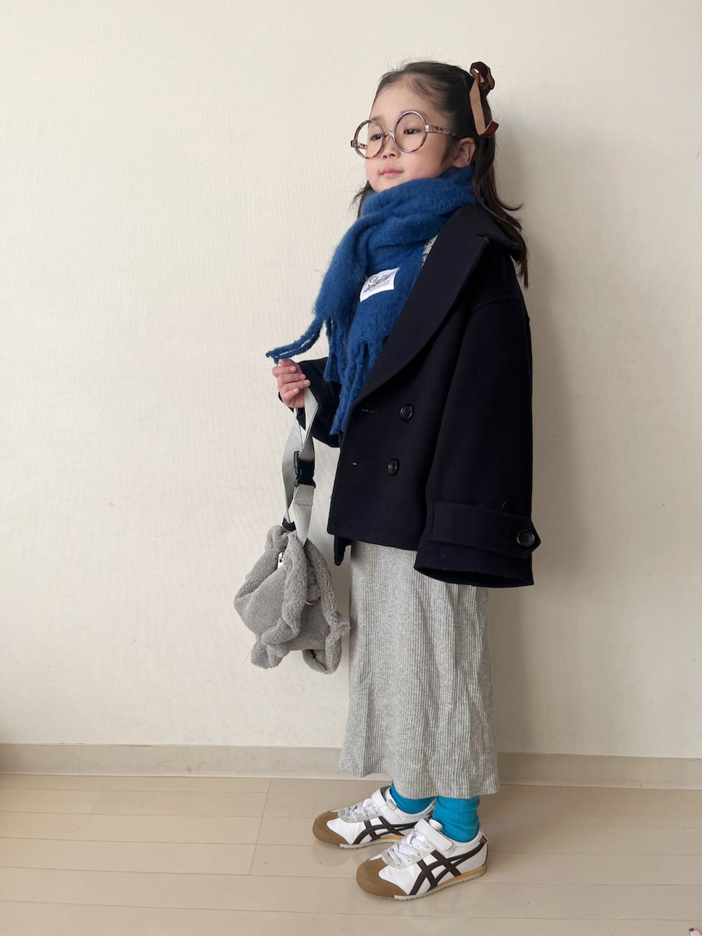 グレー系のカーディガン/ボレロ、ブルー系のピーコート、グレー系のスカートを着用したキッズの秋コーディネートの2枚目の写真