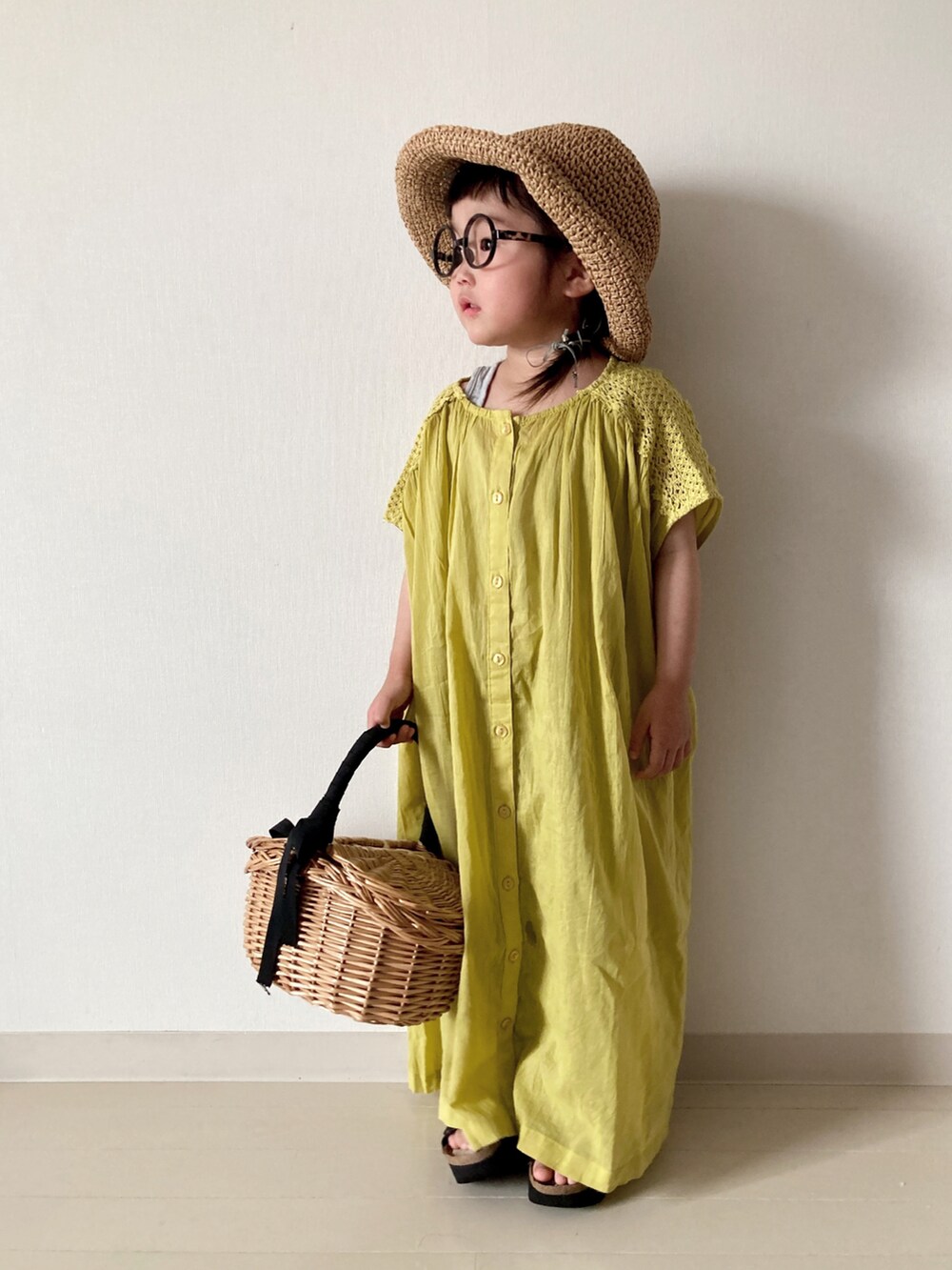 イエロー系のワンピース、グリーン系のTシャツ/カットソー、グリーン系のカーゴパンツを着用したキッズの春コーディネートの2枚目の写真