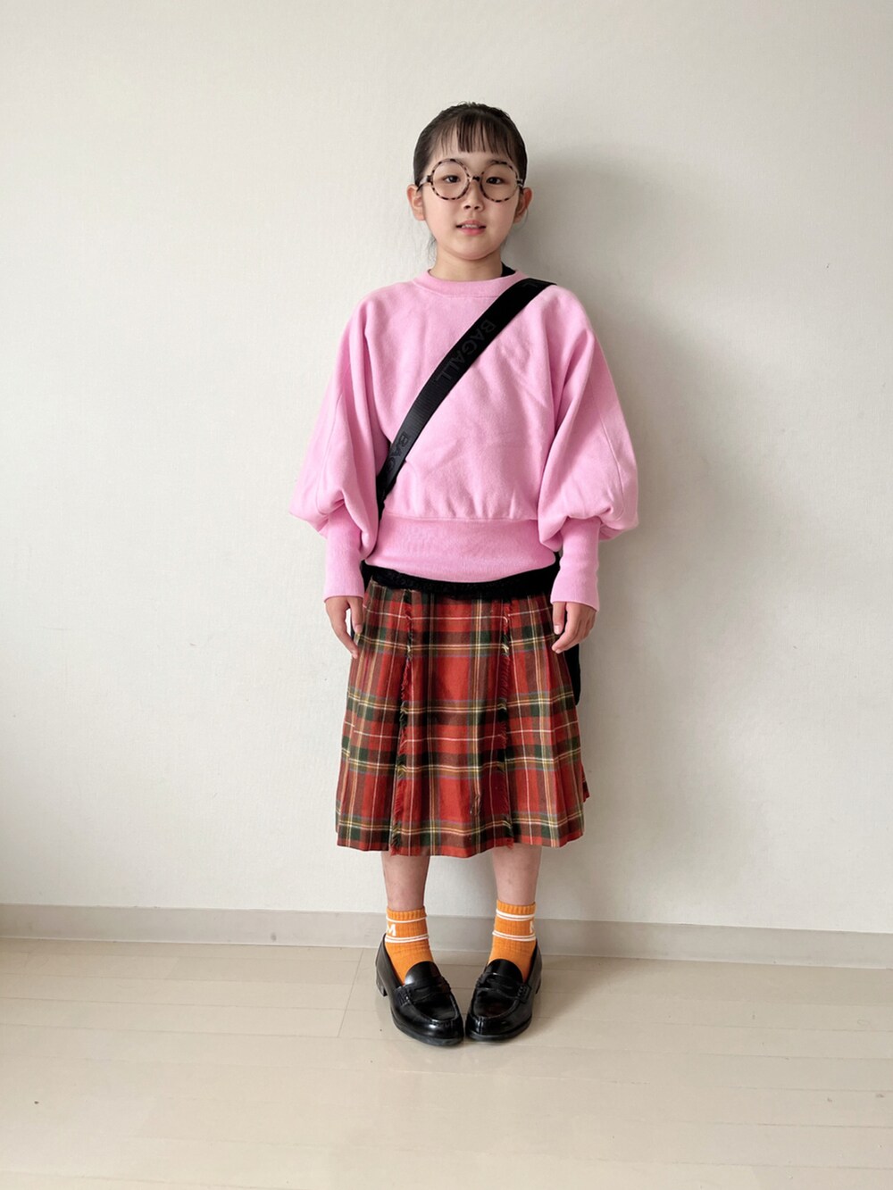 ピンク系のニット/セーター、グリーン系のダウンベスト、ブラック系のローファーを着用したキッズの秋コーディネートの3枚目の写真