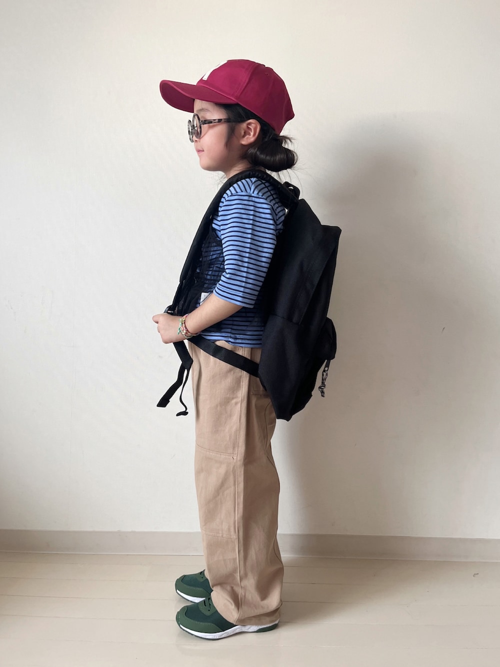 ブルー系のTシャツ/カットソー、ベージュ系のその他パンツ、ブラック系のバックパック/リュックを着用したキッズの秋コーディネートの2枚目の写真