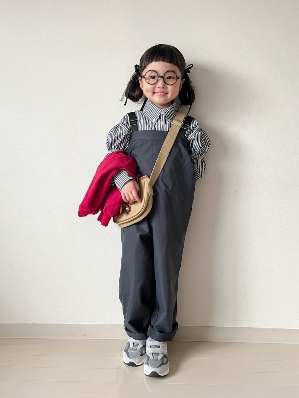 グレー系のサロペット/オーバーオール、レッド系のカーディガン/ボレロ、ブラック系のシャツ/ブラウスを着用したキッズの春コーディネートの3枚目の写真