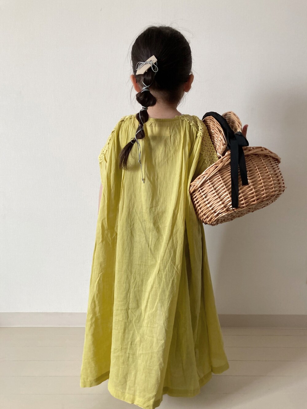 イエロー系のワンピース、グリーン系のTシャツ/カットソー、グリーン系のカーゴパンツを着用したキッズの春コーディネートの3枚目の写真