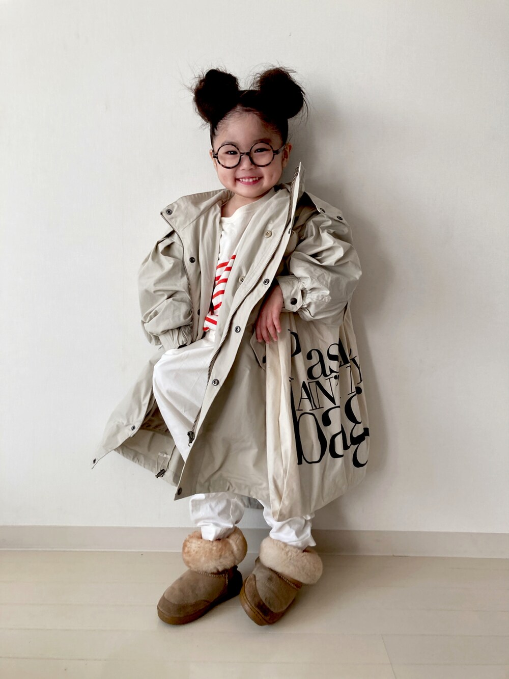 ベージュ系のモッズコート、ホワイト系のベスト、ホワイト系のその他パンツを着用したキッズの冬コーディネートの3枚目の写真