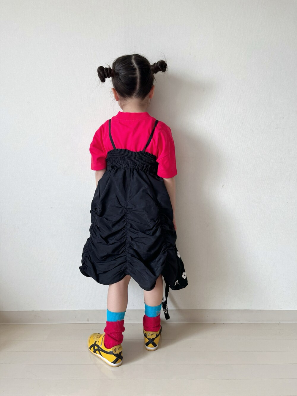 レッド系のTシャツ/カットソー、ブラック系のスカート、ブラック系のショルダーバッグを着用したキッズの春コーディネートの4枚目の写真