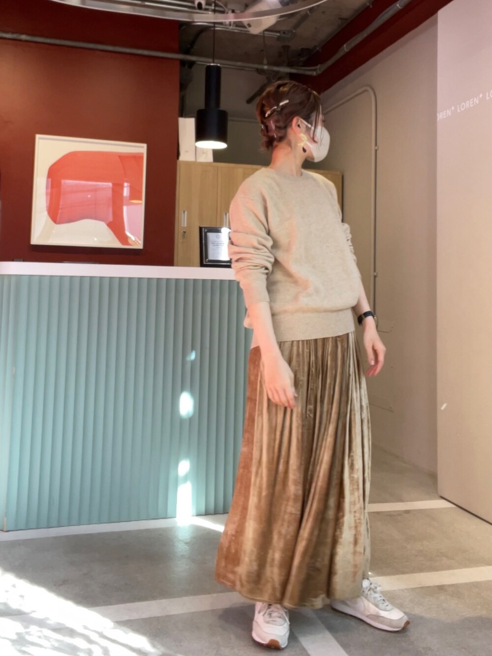 ベージュ系のニット/セーター、ゴールド系のスカート、ホワイト系のスニーカーを着用したレディースの秋コーディネートの2枚目の写真