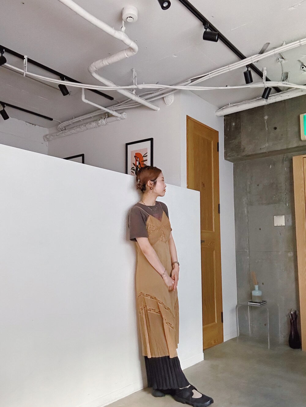 オレンジ系のワンピース、ブラック系のスニーカー、シルバー系のネックレスを着用したレディースの春コーディネートの2枚目の写真