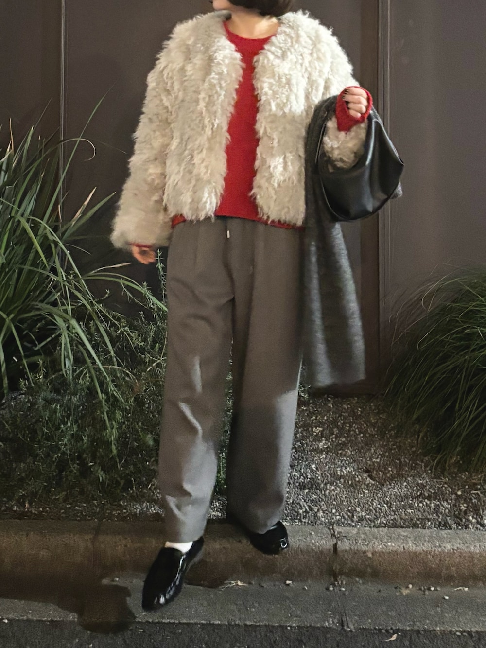 グレー系のブルゾン、レッド系のニット/セーター、ブラック系のショルダーバッグを着用したレディースの冬コーディネートの2枚目の写真