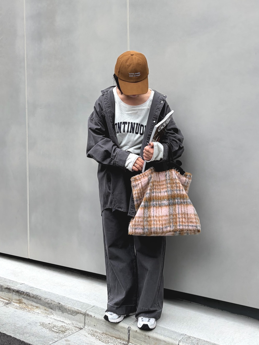 グレー系のブルゾン、グレー系のその他パンツ、イエロー系のキャップを着用したレディースの秋コーディネートの2枚目の写真