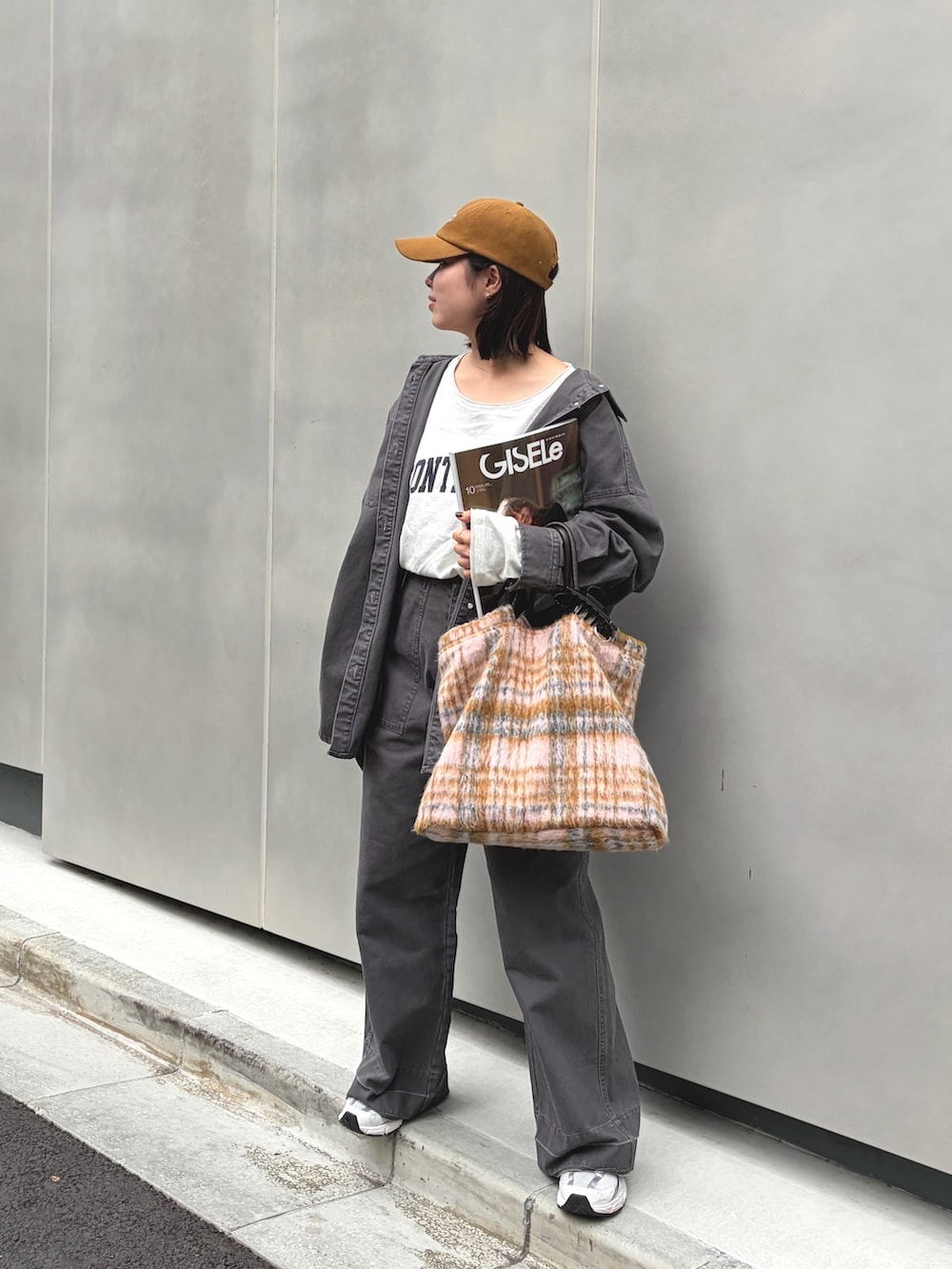 グレー系のブルゾン、グレー系のその他パンツ、イエロー系のキャップを着用したレディースの秋コーディネートの4枚目の写真
