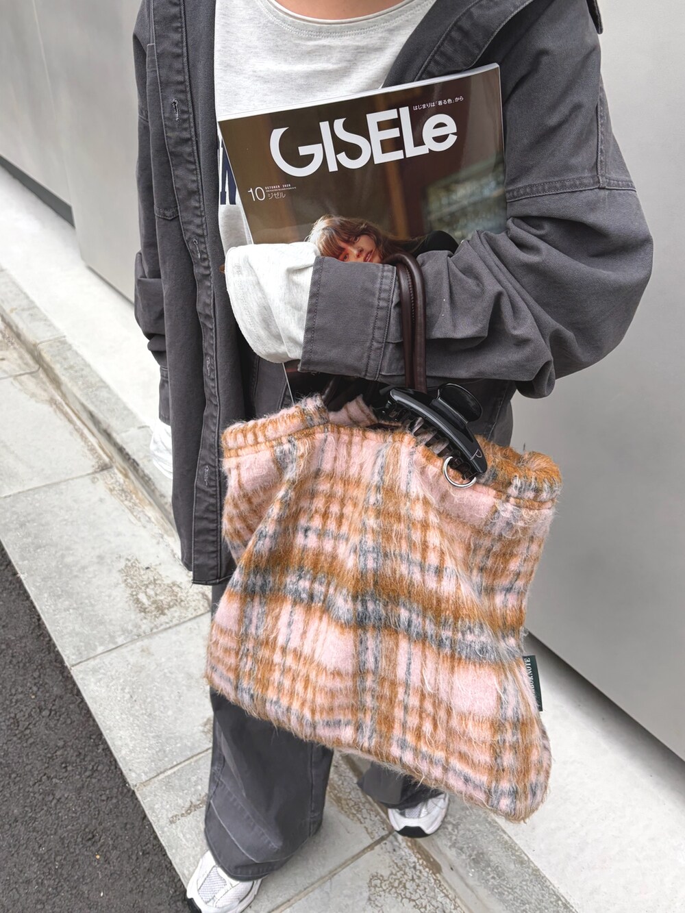 グレー系のブルゾン、グレー系のその他パンツ、イエロー系のキャップを着用したレディースの秋コーディネートの3枚目の写真
