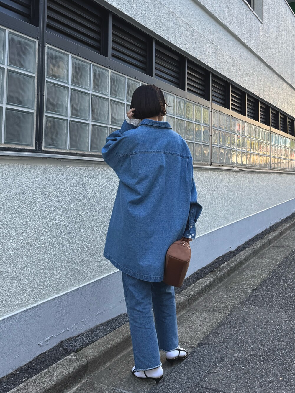 ブルー系のデニムジャケット、ホワイト系のトートバッグ、ホワイト系のその他パンツを着用したレディースの冬コーディネートの3枚目の写真