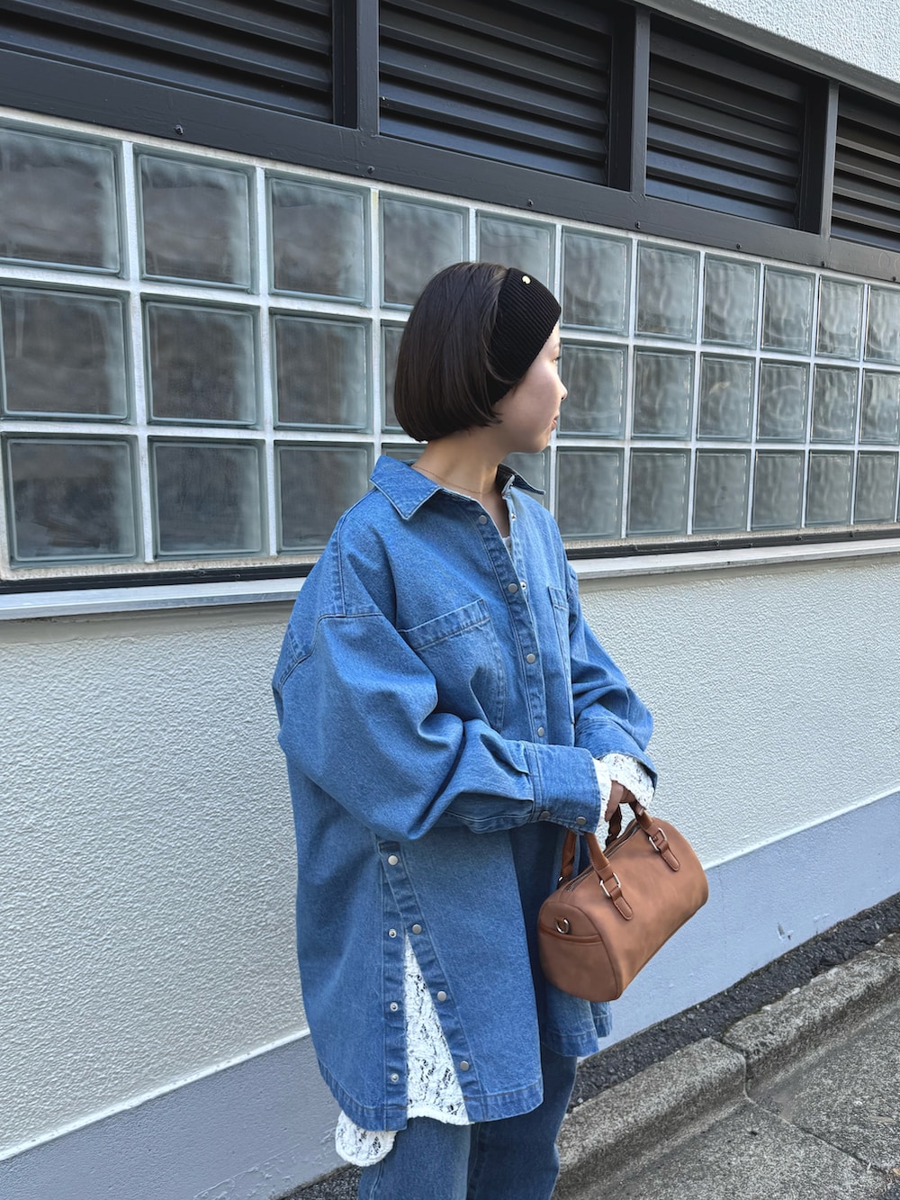 ブルー系のデニムジャケット、ホワイト系のトートバッグ、ホワイト系のその他パンツを着用したレディースの冬コーディネートの2枚目の写真