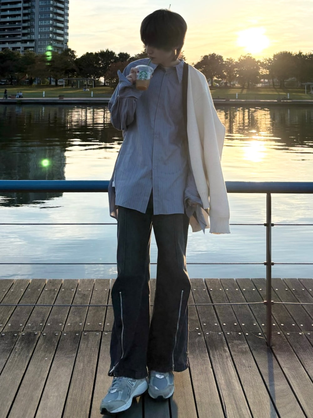 ブラック系のデニムパンツ、ホワイト系のTシャツ/カットソー、グレー系のスニーカーを着用したメンズの秋コーディネートの2枚目の写真