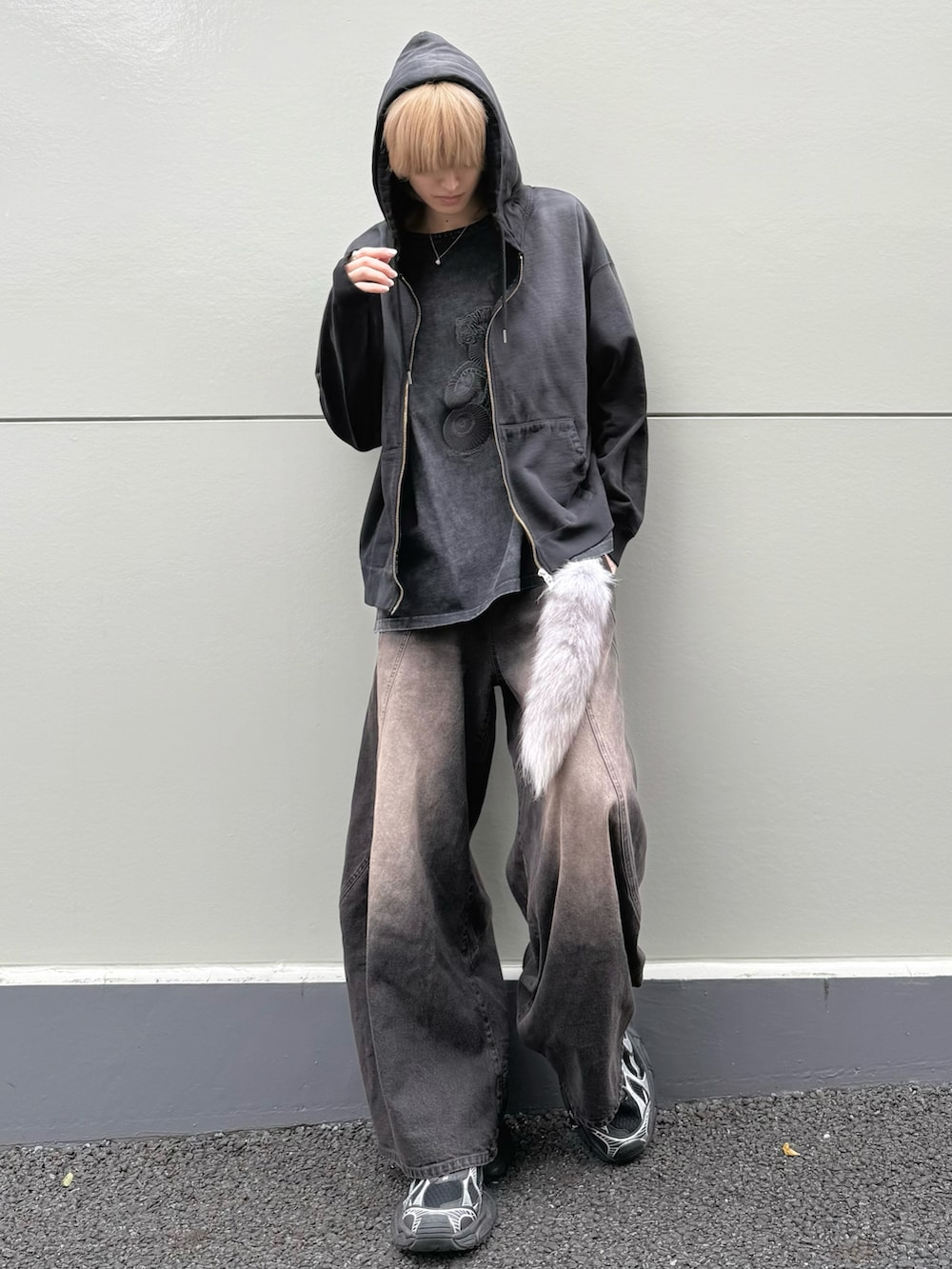 ブラック系のパーカー、ブラック系のTシャツ/カットソー、ブラウン系のデニムパンツを着用したメンズの春コーディネートの2枚目の写真