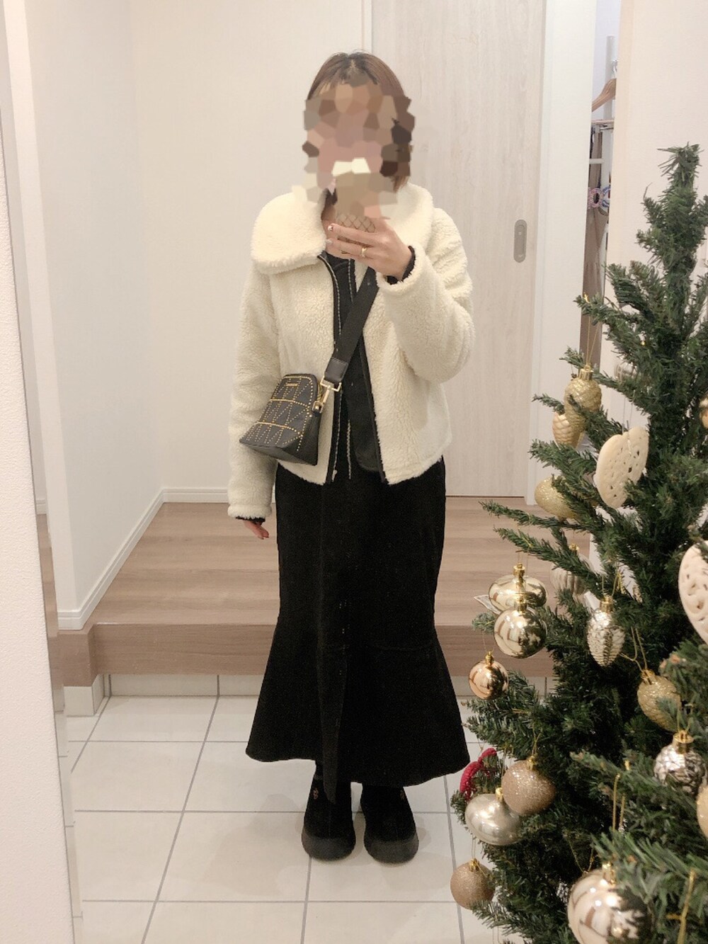 ホワイト系のジャケット/アウター、ブラック系のショルダーバッグを着用したレディースの冬コーディネートの2枚目の写真