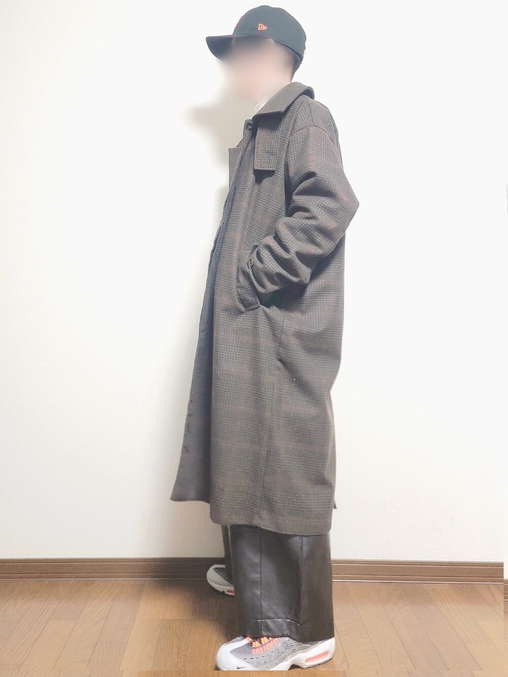 オレンジ系のノーカラージャケット、グリーン系のステンカラーコート、ブラック系のキャップを着用したメンズの冬コーディネートの2枚目の写真