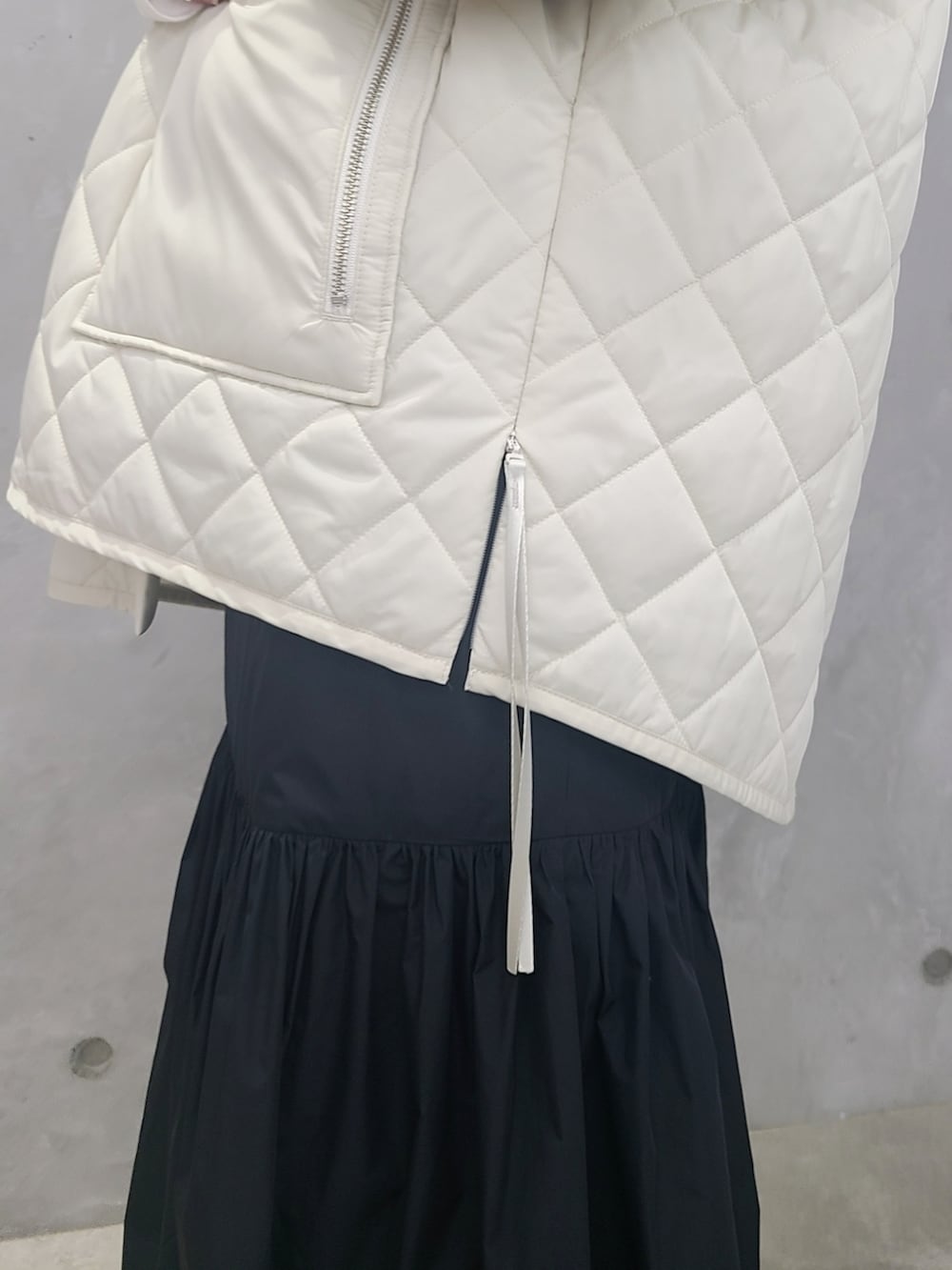 ホワイト系のブルゾン、ホワイト系のTシャツ/カットソー、ブラック系のワンピースを着用したレディースの秋コーディネートの4枚目の写真