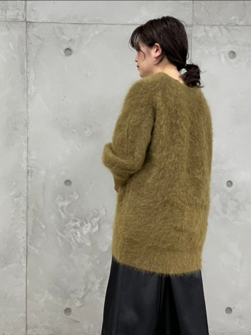 ブラック系のボストンバッグ、ブラウン系のカーディガン/ボレロ、ブラック系のスカートを着用したレディースの秋コーディネートの2枚目の写真