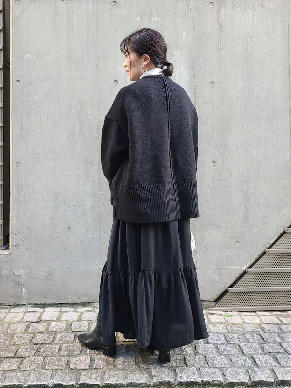 ブラック系のカーディガン/ボレロ、ホワイト系のTシャツ/カットソー、ホワイト系のボストンバッグを着用したレディースの秋コーディネートの2枚目の写真