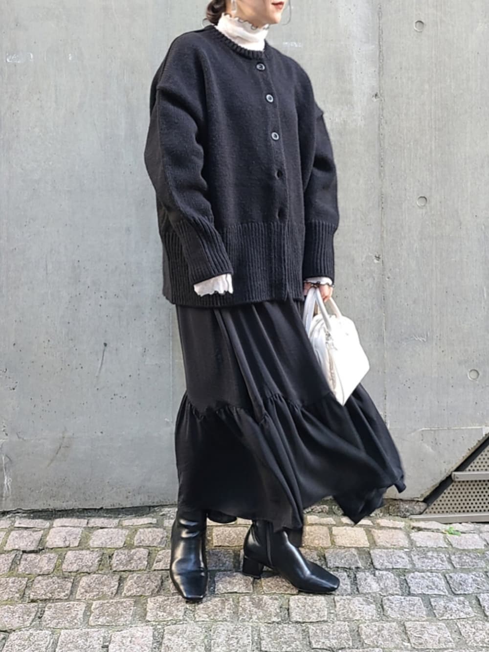 ブラック系のカーディガン/ボレロ、ホワイト系のTシャツ/カットソー、ホワイト系のボストンバッグを着用したレディースの秋コーディネートの3枚目の写真