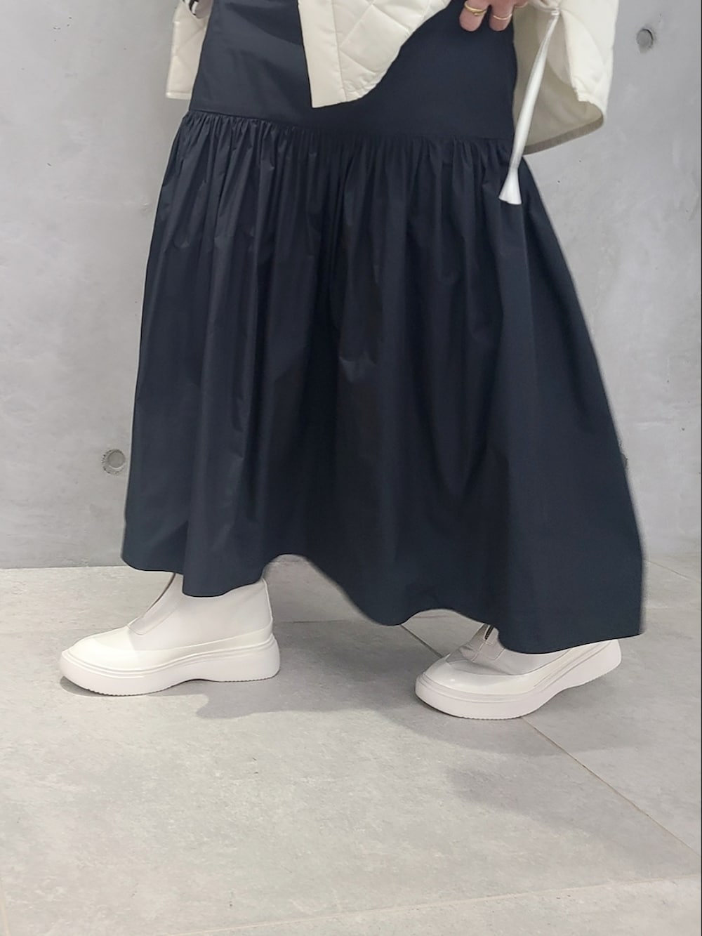 ホワイト系のブルゾン、ホワイト系のTシャツ/カットソー、ブラック系のワンピースを着用したレディースの秋コーディネートの5枚目の写真