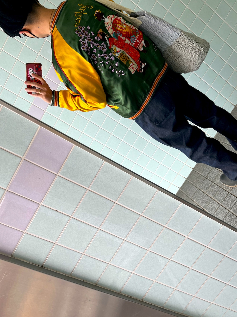 ホワイト系のTシャツ/カットソー、ブラック系のブーツ、グリーン系のスカジャンを着用したメンズの春コーディネートの2枚目の写真