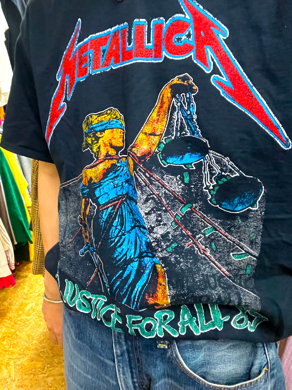 ブルー系のデニムパンツ、イエロー系のスニーカー、ブラック系のキャスケットを着用したメンズの夏コーディネートの2枚目の写真