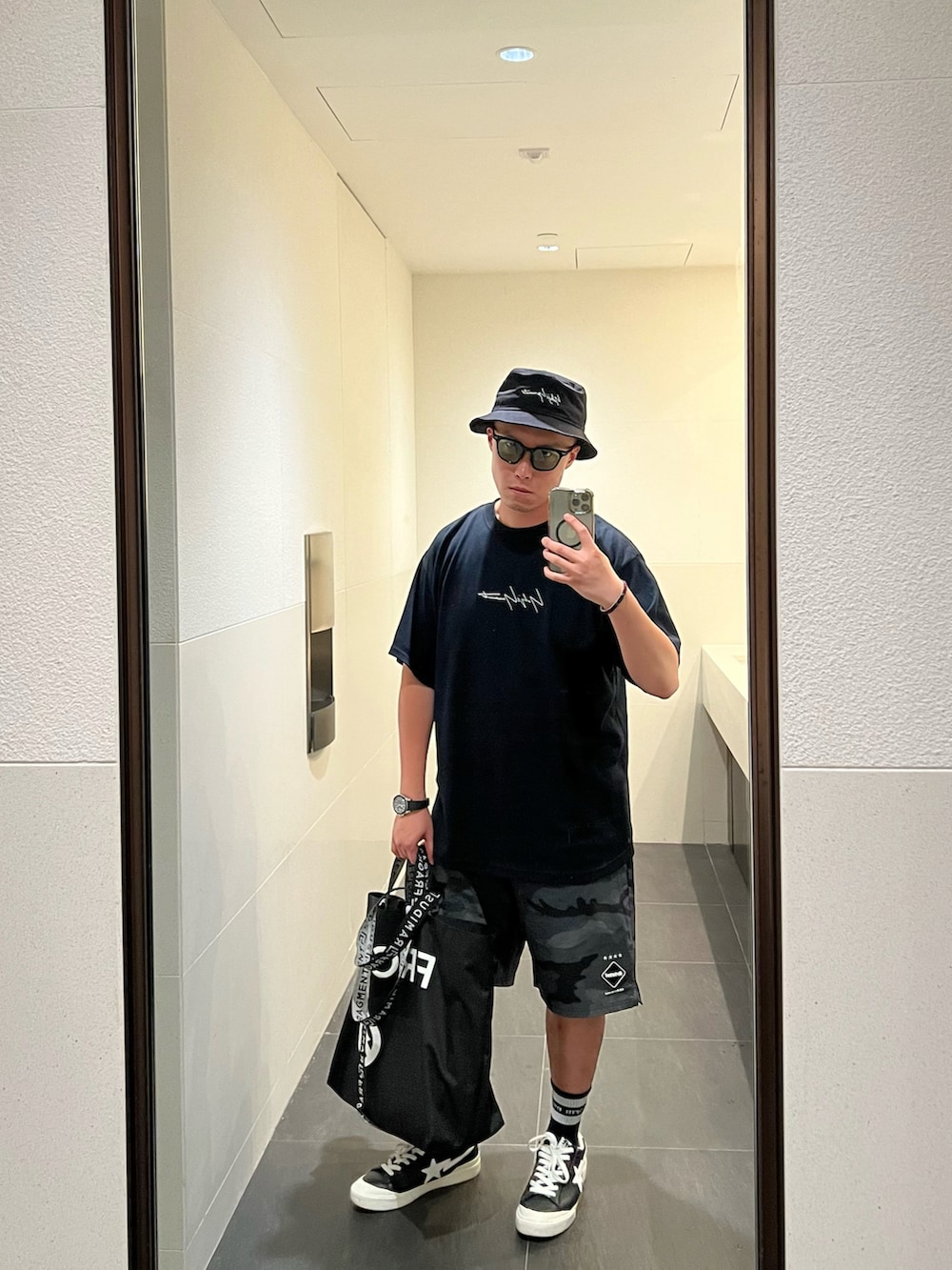 ブラック系のTシャツ/カットソー、ブラック系のトートバッグ、ブラック系のその他パンツを着用したメンズの春コーディネートの2枚目の写真