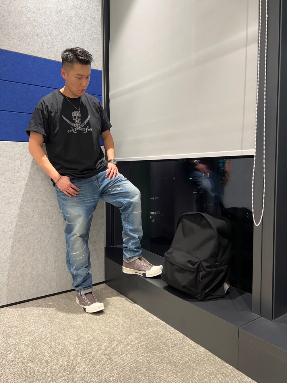 グレー系のシューズ、ブルー系のデニムパンツ、ブラック系のTシャツ/カットソーを着用したメンズの春コーディネートの2枚目の写真