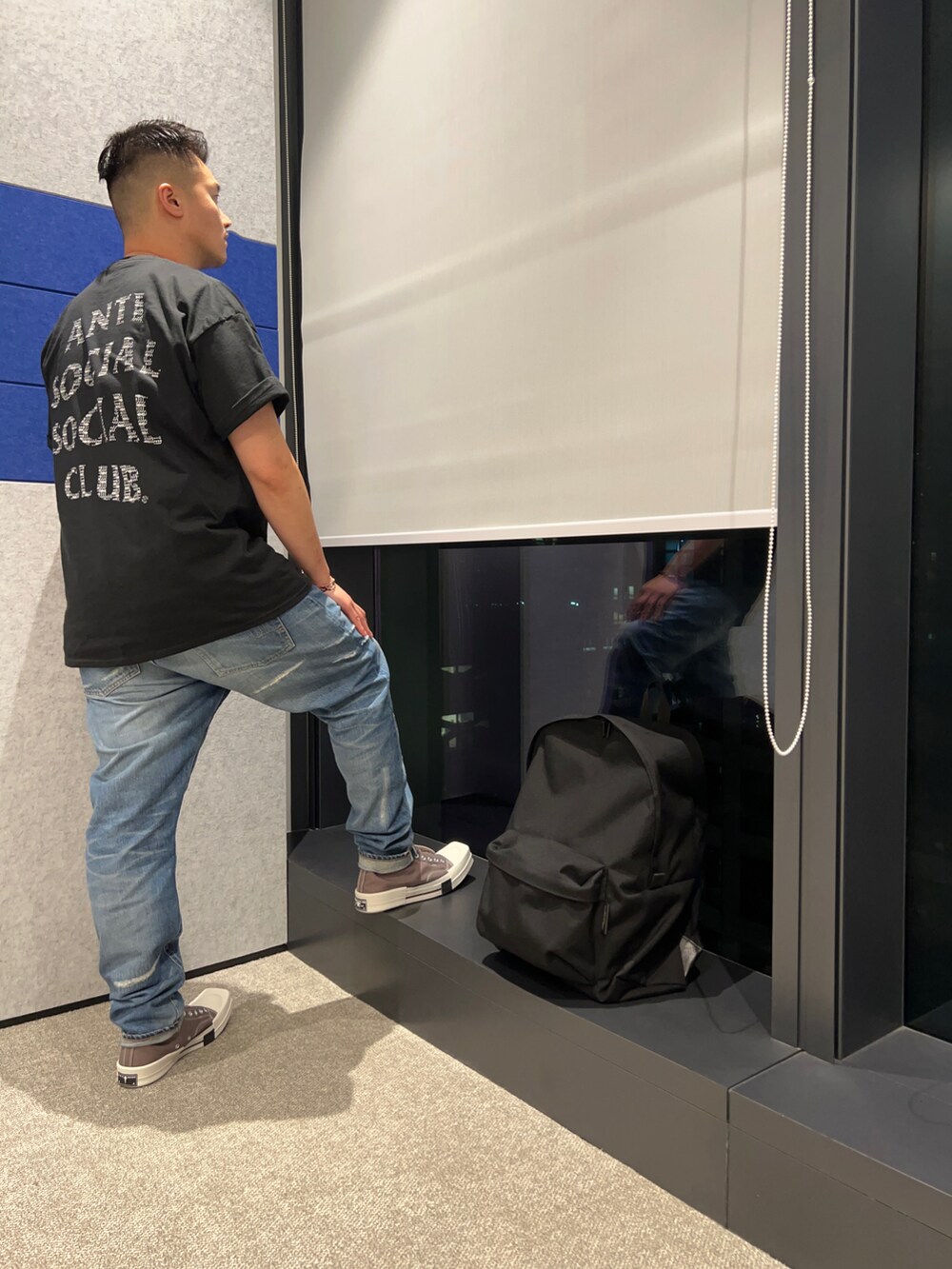 グレー系のシューズ、ブルー系のデニムパンツ、ブラック系のTシャツ/カットソーを着用したメンズの春コーディネートの3枚目の写真