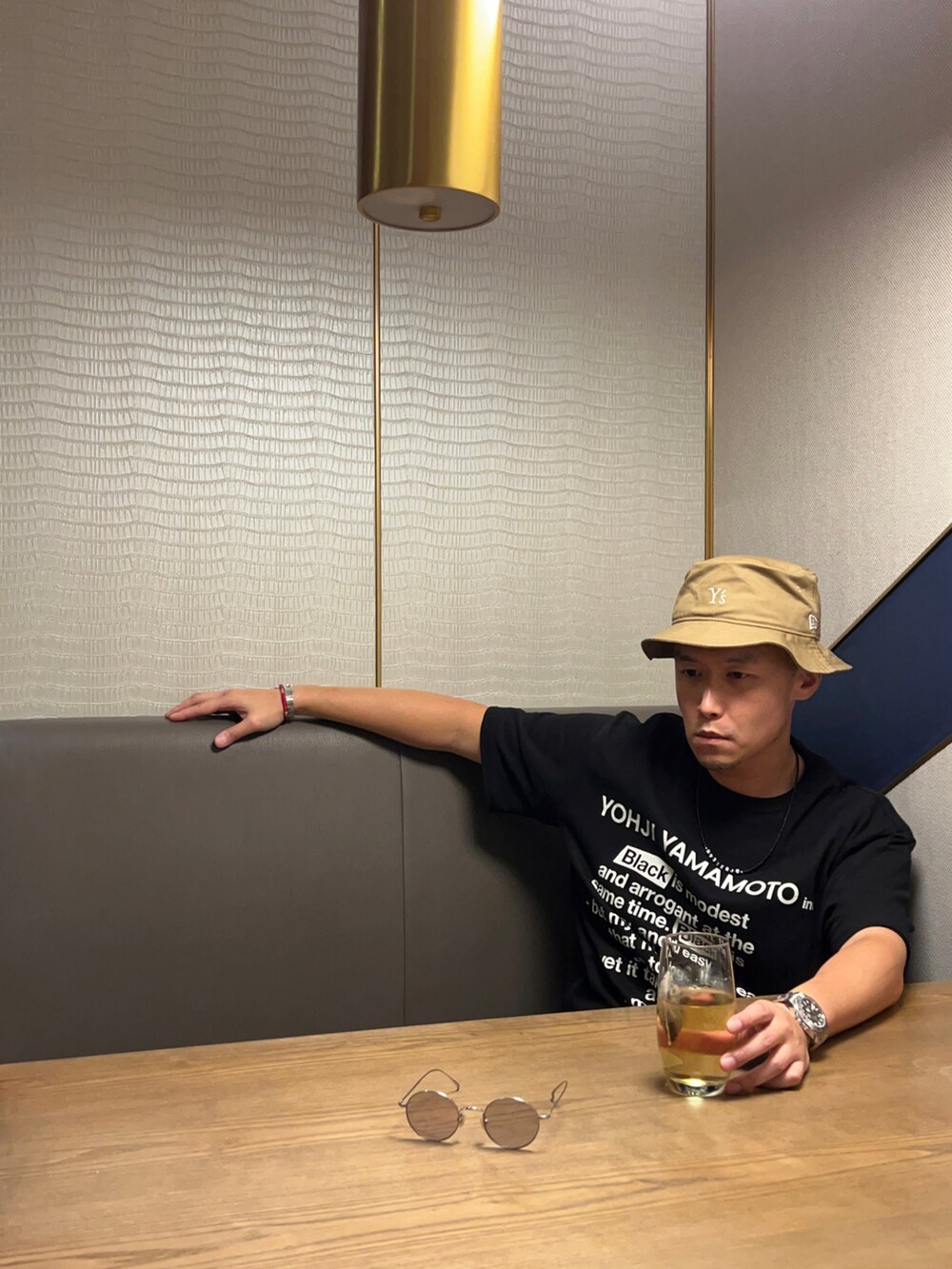 ブラック系のTシャツ/カットソー、ベージュ系の帽子、ゴールド系のサングラスを着用したメンズの秋コーディネートの3枚目の写真