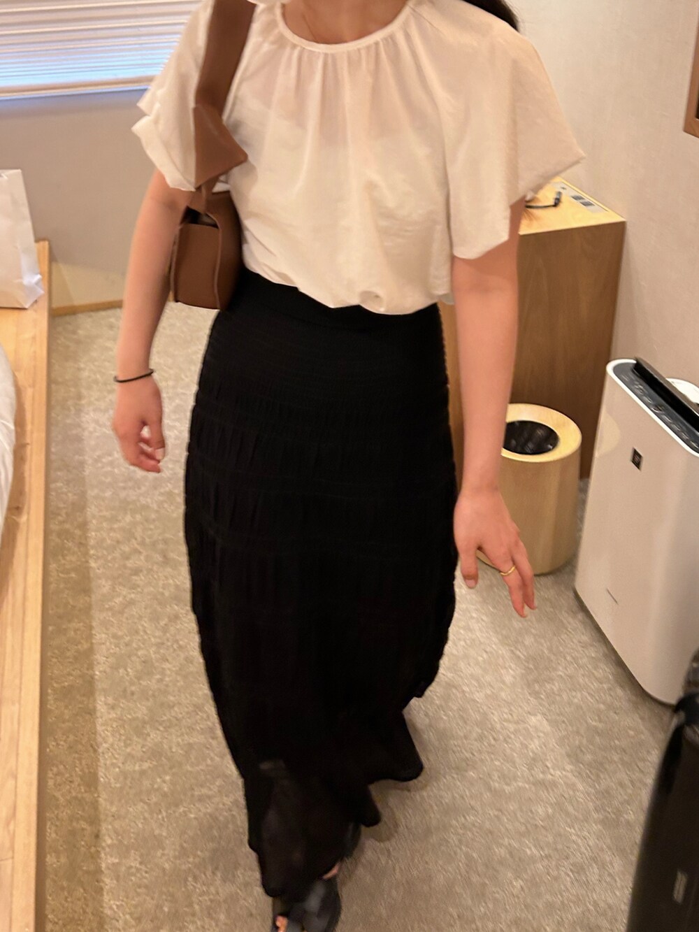 ブラウン系のショルダーバッグ、ブラック系のスカート、ブラック系のサンダルを着用したレディースの夏コーディネートの2枚目の写真