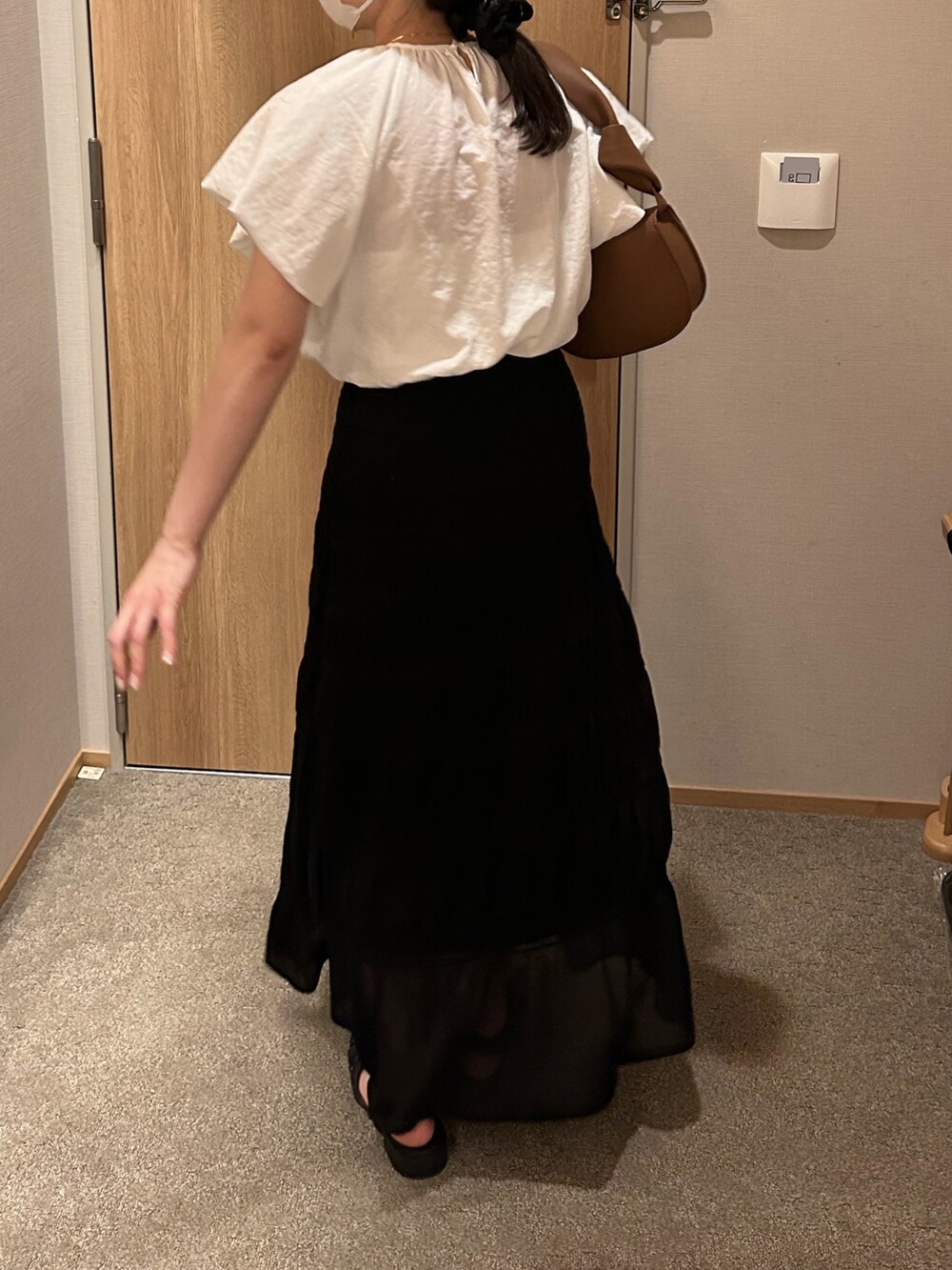 ブラウン系のショルダーバッグ、ブラック系のスカート、ブラック系のサンダルを着用したレディースの夏コーディネートの3枚目の写真