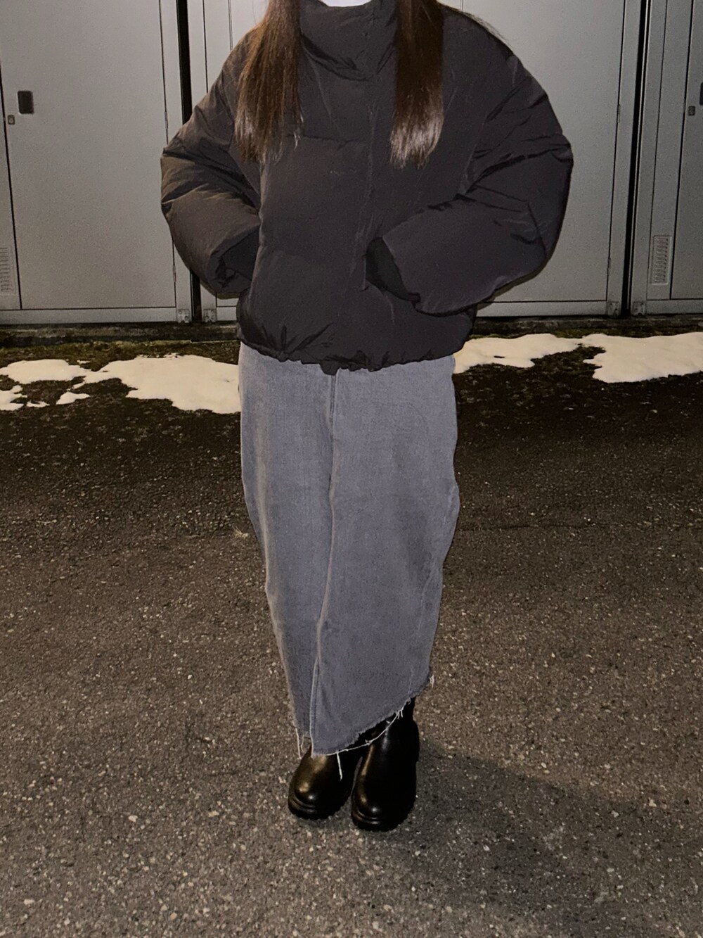 ブラック系のダウンジャケット/コート、グレー系のデニムスカート、ブラック系のブーツを着用したレディースの冬コーディネートの3枚目の写真