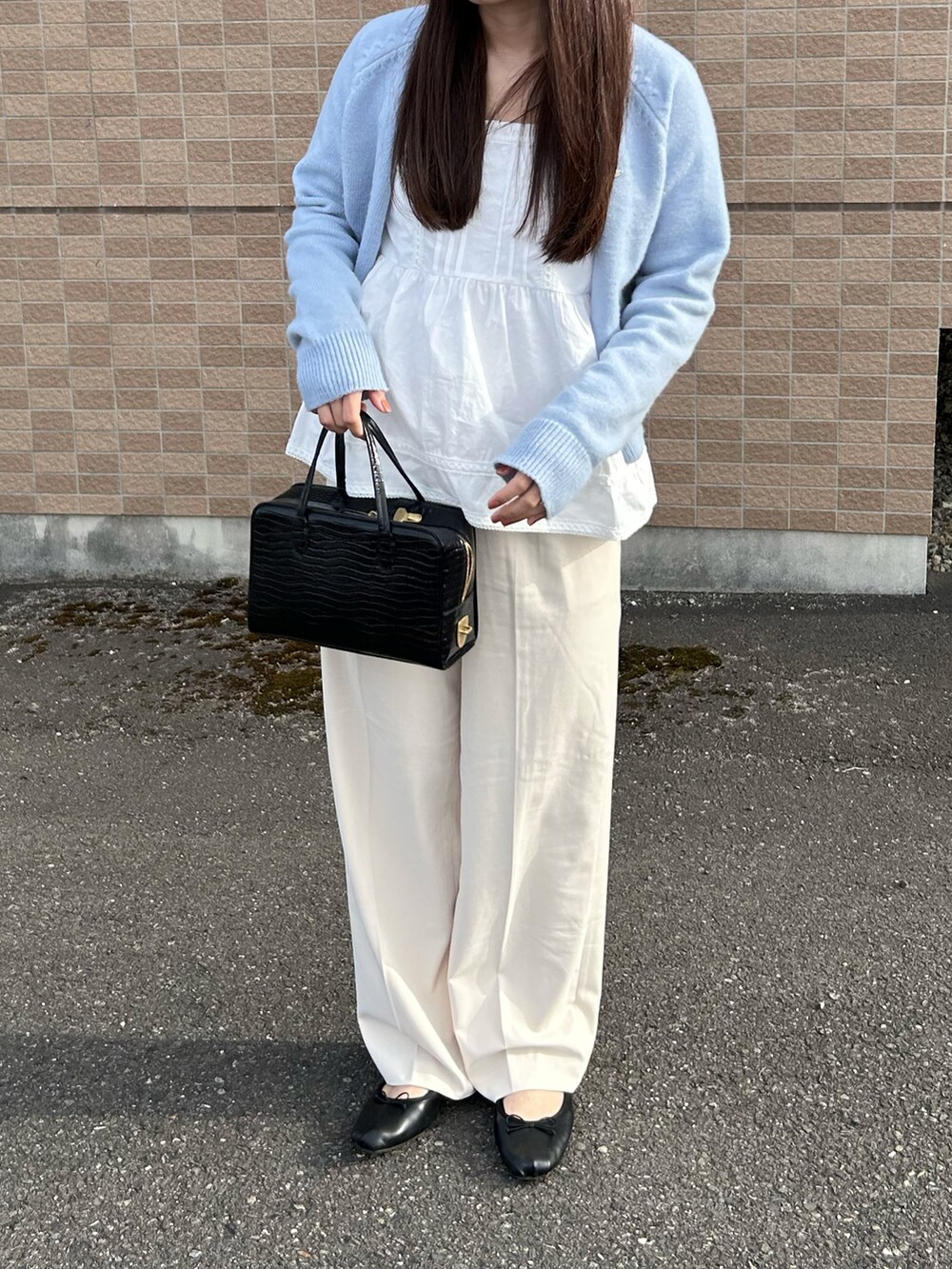 ホワイト系のキャミソール、ホワイト系のスラックス、ブラック系のバレエシューズを着用したレディースの春コーディネートの2枚目の写真