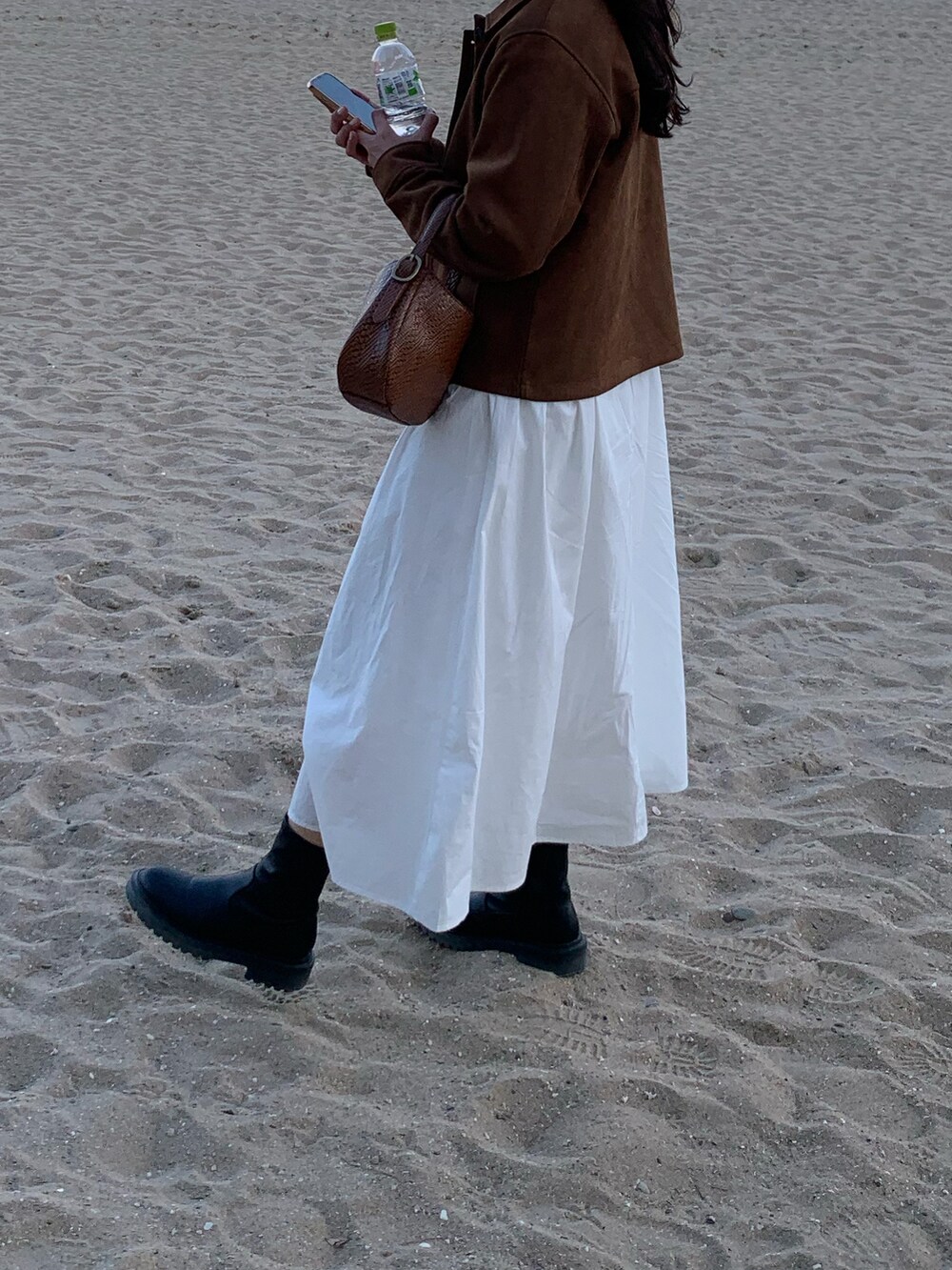 ブラウン系のジャケット/アウター、ブラック系のブーツを着用したレディースの春コーディネートの2枚目の写真