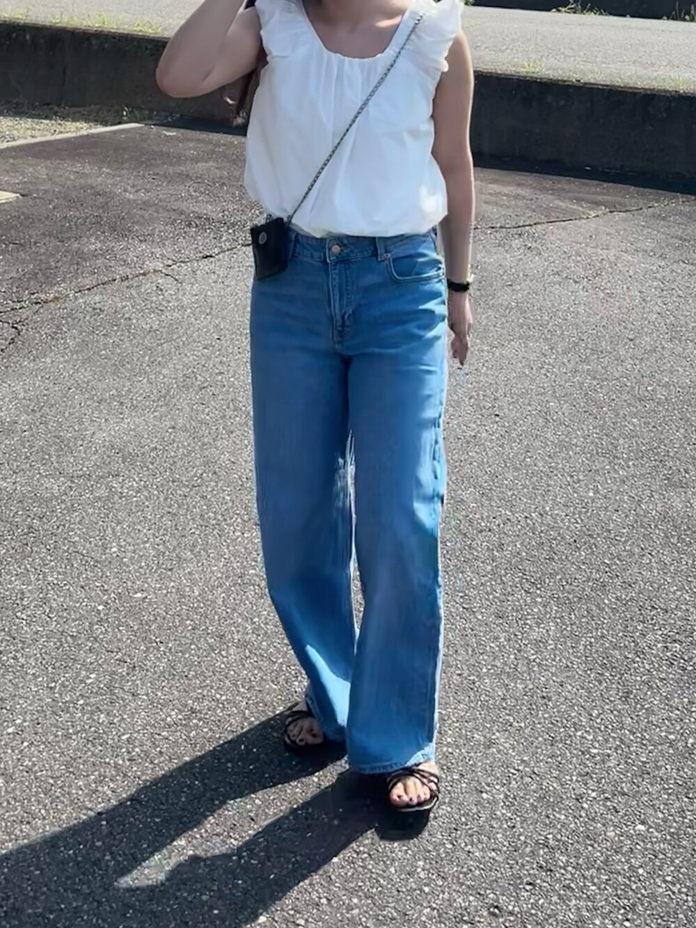 ホワイト系のシャツ/ブラウス、ブルー系のデニムパンツ、ブラック系のショルダーバッグを着用したレディースの夏コーディネートの3枚目の写真