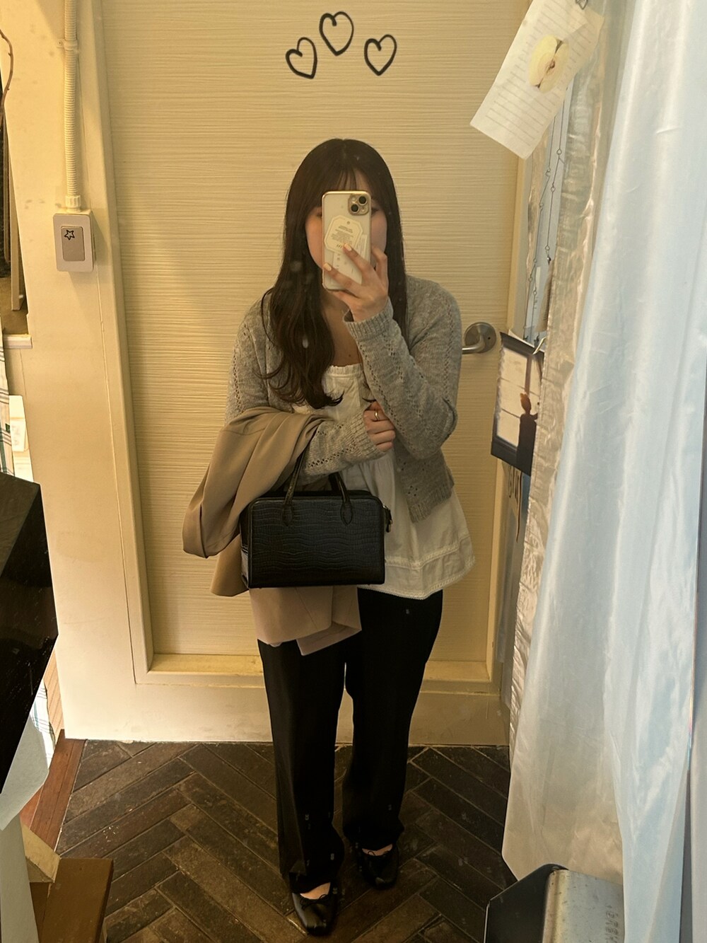 ブラック系のスラックス、ブラック系のバレエシューズ、ホワイト系のキャミソールを着用したレディースの春コーディネートの2枚目の写真