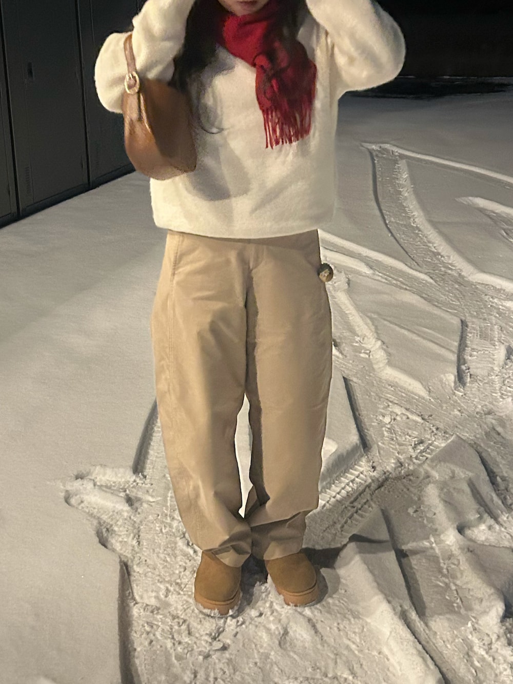 ベージュ系のパンツ、イエロー系のブーツを着用したレディースの冬コーディネートの2枚目の写真