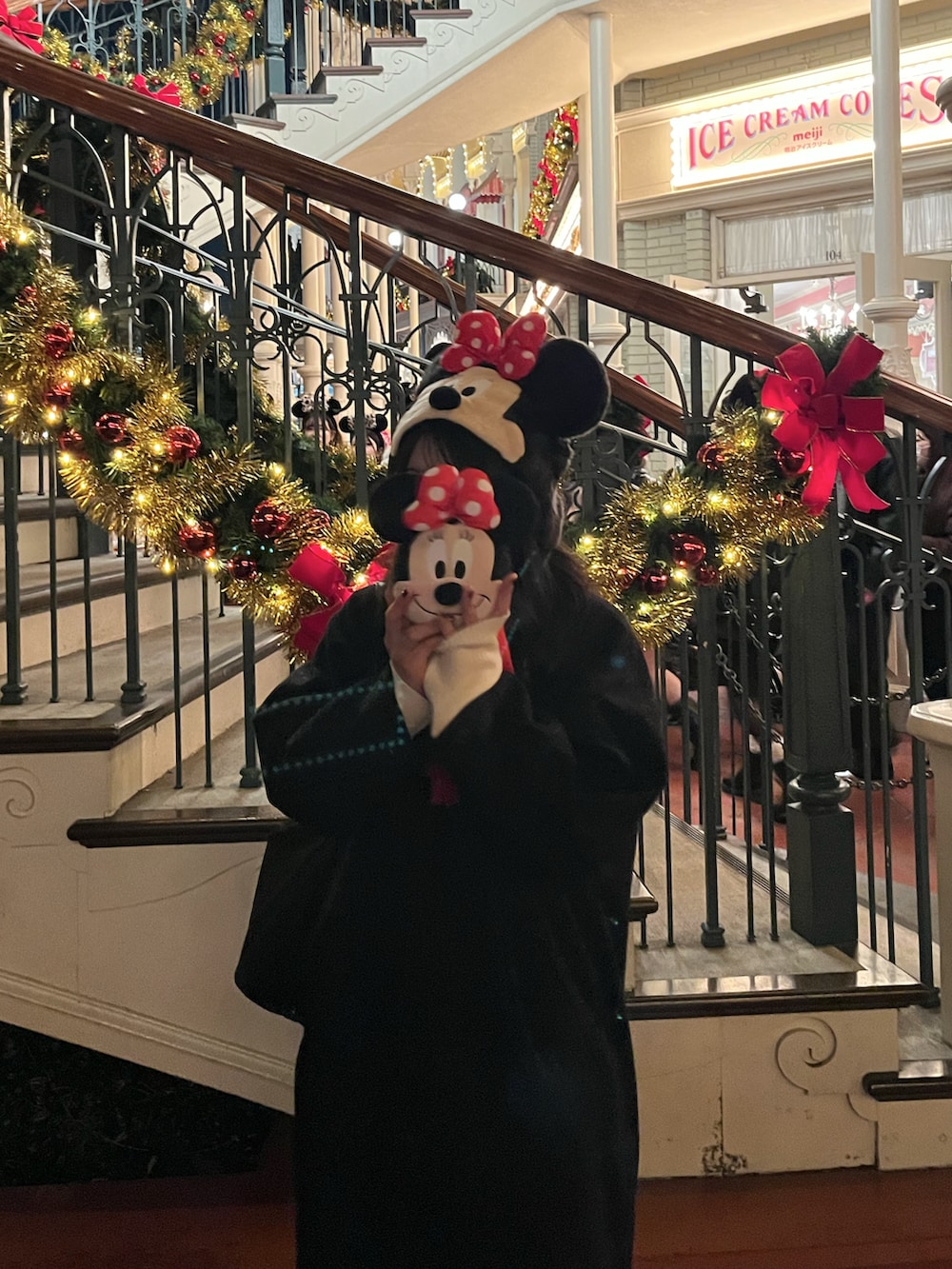 ブラック系のステンカラーコート、ホワイト系のニット/セーター、ブラック系のスニーカーを着用したレディースの冬コーディネートの3枚目の写真